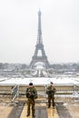 Soldiers patrolling on the Trocadero esplanade in Paris, opposite the Eiffel tower, on a snowy day