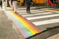 Paris, France 2019. Gay pride flag, Rainbow flag of the LGBT community on crosswalk with people crossing in Paris. LGBT flag as a