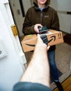 Male hand taking through the open door the cardboard parcel from Amazon Prime Royalty Free Stock Photo