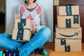 Smiling woman unboxing amazon cardboard boxes