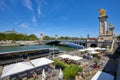 Alexandre III bridge with people and tourists and cafe in docks area in a sunny summer day, blue Royalty Free Stock Photo