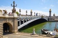 Alexandre III bridge with people and tourists in a sunny day, blue sky in Paris, France Royalty Free Stock Photo