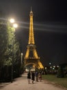 PARIS, FRANCE Ã¢â¬â July 24, 2019: The Eiffel Tower at night. People are walking near La Tour Eiffel in the evening. Light from a Royalty Free Stock Photo