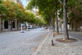 Empty parisian street and sidewalk with green trees in a summer day in Paris, France