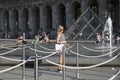 Girl takes a selfie in the square in front of the Louvre Museum in Paris