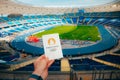 PARIS, FRANCE, JULY 7, 2023: Icon of Summer olympic Games Paris 2024 Held by Athlete. Modern Olympic Stadium in background. Royalty Free Stock Photo