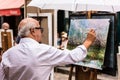 The painter works at the Tertre Square Place du Tertre in Mont