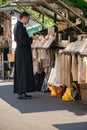 Priest at book stall along river Seine.