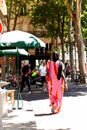 Rear view of an African woman in colorful dress walking in the street of Paris, France