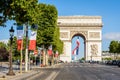 A large french flag flies under the Arc de Triomphe in Paris, France