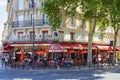 Paris, typical cafe brasserie with sidewalk tables with people and tourists sitting in a sunny day