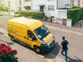 Man courier walking toward la Poste yellow delivery van