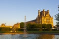 A few people gather around a water-fountain located near the Ecole du Louvre Royalty Free Stock Photo