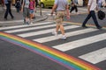 Gay pride flag crosswalk in Paris gay village with people crossing Royalty Free Stock Photo