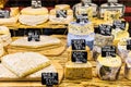 Different cheeses on the counter of a small store at the Aligre