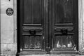 Paris, France - June 26, 2019: Scratched wooden double door with vintage handles. Shabby surface of antique gate.