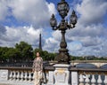 Tourist enjoys sunny day on the Pont Alexandre III in Paris, France