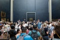 Tourists crowd to take photos of the famous Mona Lisa painting of Leonardo da Vinci inside the Louvre museum