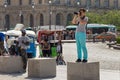 PARIS, FRANCE - JUNE 23, 2017: Unknown young woman standing on the concrete cube and taking a photo of the famous Louvre Palace in