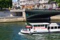 PARIS, FRANCE - JUNE 23, 2017: White tourist boat under Pont D`Arcole bridge on the Seine river in the center of Paris near Hotel