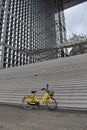 Paris, France. Yellow bicycle in Grande Arche. La Defense business district. Rainy day.