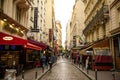 Paris, France - 24.04.2019: Latin Quarter. Narrow street of Paris among old traditional parisian houses and cafe in Royalty Free Stock Photo