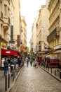 Paris, France - 24.04.2019: Latin Quarter. Narrow street of Paris among old traditional parisian houses and cafe in Royalty Free Stock Photo