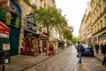 Paris, France - 24.04.2019: Latin Quarter. Narrow street of Paris among old traditional parisian houses and cafe in Royalty Free Stock Photo