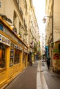 Paris, France - 24.04.2019: Latin Quarter. Narrow street of Paris among old traditional parisian houses and cafe in Royalty Free Stock Photo