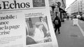 Man reading buying French Les Echos newspaper at press kiosk Street