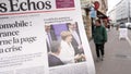 Man reading buying French Les Echos newspaper at press kiosk Street