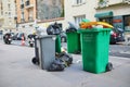 Paris, France - March 12, 2023: Messy streets with overfull garbage bins during binmen strike in Paris, France