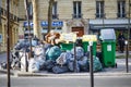 Paris, France - March 16, 2023: Messy streets with overfull garbage bins during binmen strike in Paris, France