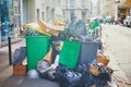 Paris, France - March 16, 2023: Messy streets with overfull garbage bins during binmen strike in Paris, France