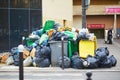 Paris, France - March 16, 2023: Messy streets with overfull garbage bins during binmen strike in Paris, France