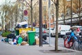 Paris, France - March 16, 2023: Messy streets with overfull garbage bins during binmen strike in Paris, France