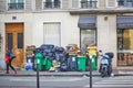 Paris, France - March 16, 2023: Messy streets with overfull garbage bins during binmen strike in Paris, France