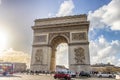 Paris, France - March 14, 2018: view of Arc de Triomphe with the busy cobblestone street, on backlight, at sunset