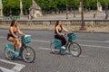 PARIS, FRANCE - MAY 25, 2019: Girls cycling down the street. The public bike system in Paris Royalty Free Stock Photo