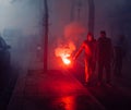 Protestors wearing a Guy Fawkes mask light gas canisters to express their anger against French President Macro`s government, amon Royalty Free Stock Photo