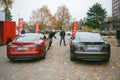 Two men looking comparing new electric Tesla Motors cars P85 and P85 plus