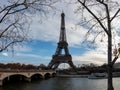 Cityscape of Paris in fall. Ships and brigde over Seine river with Eiffel tower in background and dramatic cloudy sky