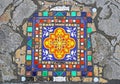Closeup of mosaic created by french street artist Ememem incorporated in cracked sidewalk in front of Notre Dame square