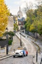 A vintage french car driving down a small street of Montmartre district in Paris Royalty Free Stock Photo