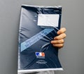 Man holding against gray background envelope containing Taxe d`h