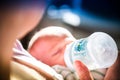 Woman giving formula to infant baby in the Philips Avent baby bottle