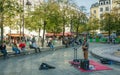 A musicians entertains young people sitting around a fountain Paris, France