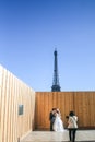 PARIS, FRANCE - OCTOBER 18, 2014: Newly married couple posing in front of the Eiffel Tower shortly after their wedding Royalty Free Stock Photo