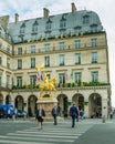 Parisians walk along Rue de Rivoli in front of Hotel Regina