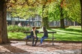 PARIS, FRANCE - OCTOBER 3, 2020: People sitting on the bench and talking in Luxembourg garden, Paris, France